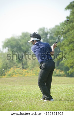 Businessman playing golf on vacation.man 
Golfers are taking a major hit to win a championship on tee or fairway to participate in a national tournament.Golf sport is Balance of Yin Yang.
