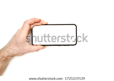 male hand holds a modern black smartphone on a white background. white display. blank for different ideas. mockup on white. top view.