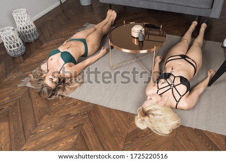 Crime scene imitation. Two lifeless beautiful women in a room. The were shot in the chest
