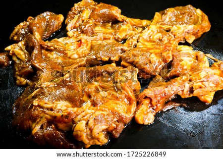 A picture of marinated black pepper and herbs mutton on black tray.