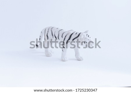 Toy albino tiger on flat background  
