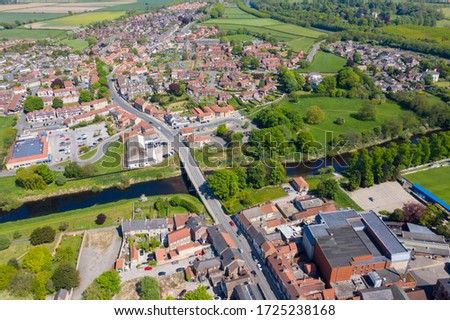 Aerial photo of the the historic town of Tadcaster and the main bridge going over the River Wharfe located in the West Yorkshire British town of Tadcaster, taken on a bright sunny summers day