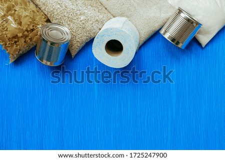 Shelf food in the assortment of pasta, cereals, canned food on a blue background, top view, mine space, flat lay. The concept of home food stocks for the period of quarantine