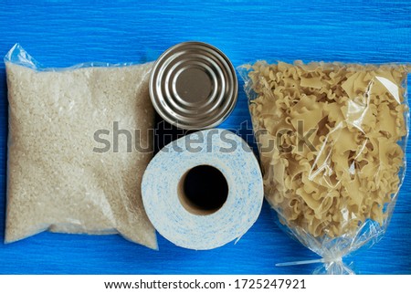 Shelf food in the assortment of pasta, cereals, canned food on a blue background, top view, mine space, flat lay. The concept of home food stocks for the period of quarantine