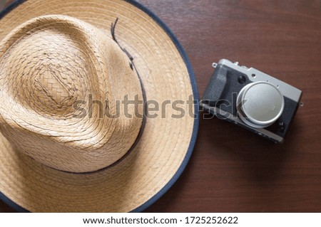 hat, brown table and gray camera 