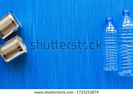 Recycling. Materials for recycle and reuse plastic bottle, tin can on blue background. Top view. Flat lay