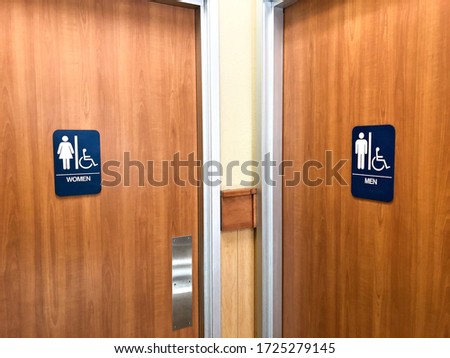 Two Public restroom doors with blue signs specifying male and female with handicap accessible features in both.