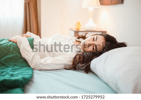 Young woman asia wake up refreshed in the morning and relax in the bedroom on holiday. Asian, asia, relax, alone, technology, lifestyle concept.