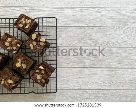 Delicious Chocolate brownie cakes with chocolate chips and almonds slices on baking rack isolated on white background. Selective focus. Top view or flat lay. Copy space.