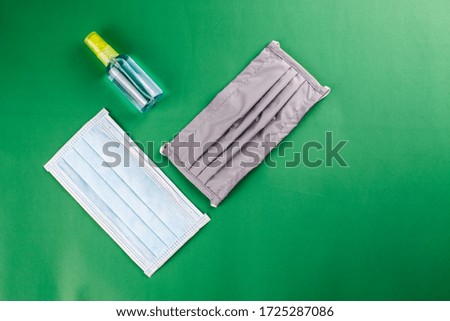 Close up Medical surgical N95 mask and alcohol spray isolated on green background with clip path, protect virus COVID 19 and dust pm 2.5pollution that a big problem and spread widely in 2020 