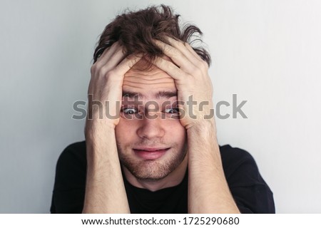 crazy young unshaven guy holding his head, obsessive thoughts, headache, problems, schizophrenia, concept Royalty-Free Stock Photo #1725290680