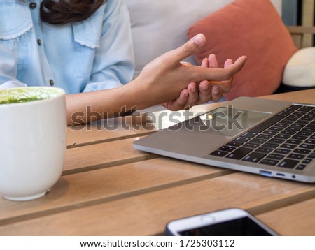 A woman has finger and hand pain after sitting in a computer for a long time. Office syndrome concept