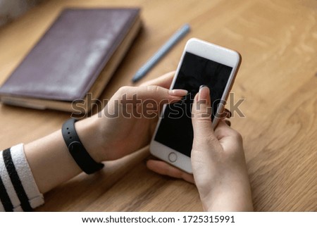 A woman's finger points at a smartphone screen, communicates in social networks, meets a website,
searches the Internet, sends sms, uses text messenger or online