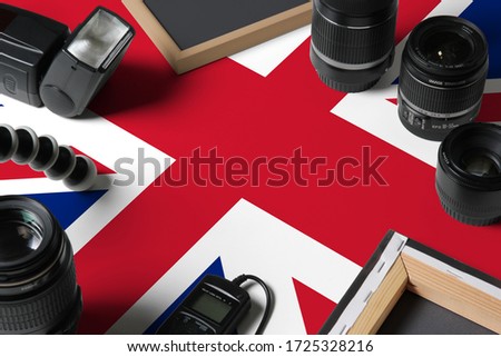 United Kingdom national flag with top view of personal photographer equipment and tools on white wooden table, copy space.