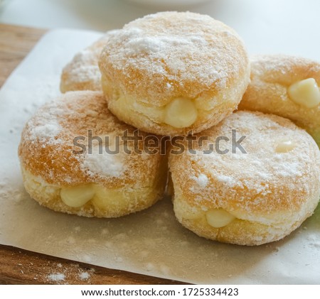 Bomboloni, fill in durian fruit.  served on a rustic wooden tray.  on a white table