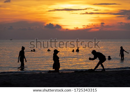 Tourists take photos of the sunset view.Silhuoette picture style at Mae Ramphueng Beach in Rayong Province of Thailand.
