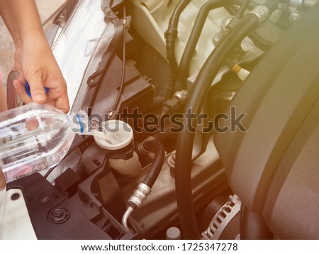 Adding water to the car radiator should open the hood once a week to observe the water in the radiator. And reserve water tank In order to be aware If something goes wrong with the radiator Royalty-Free Stock Photo #1725347278
