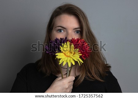 young blonde girl with three red, yellow and purple flowers on her face