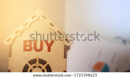 Buy word on Toy wooden house. Real estate property concept.