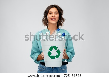 recycling, waste sorting and sustainability concept - smiling young woman in striped t-shirt holding bucket with plastic bottles over grey background