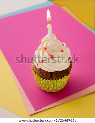 Cupcake decorated with whipped cream and decorative hearting