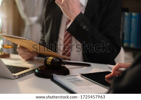 Lawyer businessman and two business partners working together in office. Businessmen sitting at desk and making notes.