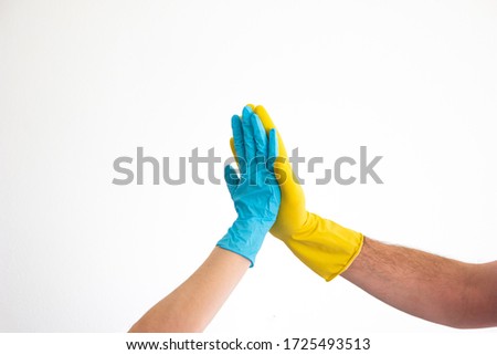 Caucasian woman and man hands and arms in blue and yellow latex gloves doing the high five sign isolate on white 2020