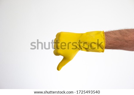 Caucasian male hand in yellow latex glove doing the thumbs down sign front view isolated on white 2020