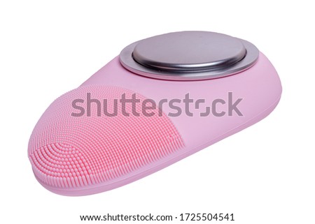 Beauty and skin care concept. Close-up of a modern pink, electrically rechargeable silicone brush for facial cleansing with massage vibration isolated on a white background. Macro photography.