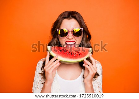 Photo of cheerful cute nice positive charming youth girl about biting wedge of juicy watermelon enjoying summer isolated over vivid color background in eyewear eyeglasses spectacles