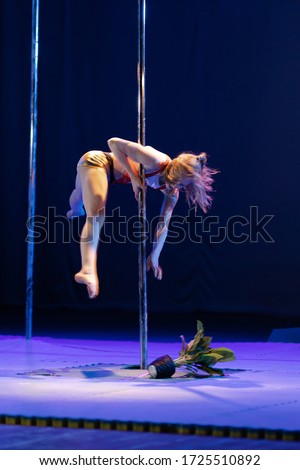 Girls gymnasts show an acrobatic performance on the pylon and dance on stage in the theater.