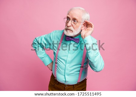Photo of attractive grandpa hold hand near ear listening rumors focused chatterbox bad person wear specs mint shirt suspenders bow tie pants isolated pink pastel color background Royalty-Free Stock Photo #1725511495