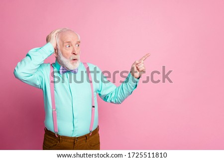 Photo of cool stylish look aged man guy open mouth indicating finger empty space showing crazy sales wear mint shirt suspenders bow tie pants isolated pastel pink color background