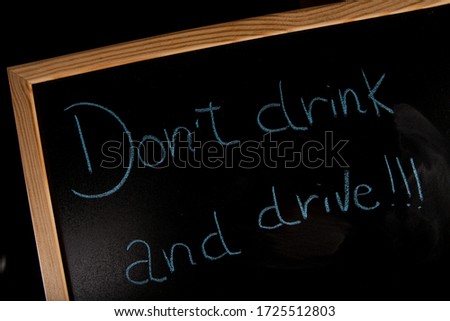 written "don't drink and drive !!!" drawn in chalk on the blackboard over a table