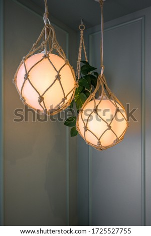 A vertical shot of two beautiful round lamps hung from the corner of a ceiling