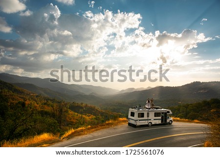 RV road trip. Young people enjoy freedom and an epic nature mountain view from the roof top of an RV motorhome. Traveling lifestyle roadtrip adventure in the USA Royalty-Free Stock Photo #1725561076