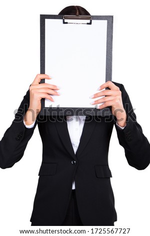 Shot of a young business woman  closing her face by paper tablet. Stock photo 