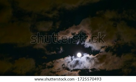 the moon shines brightly through the clouds in the night sky