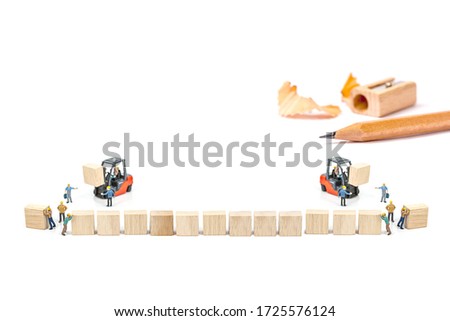 selective focus of miniature worker people, working front of forklift machine with wood block and sharpen pencil isolated on white background.