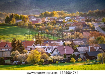 Village in spring evening, small houses and beautiful orange sunset light