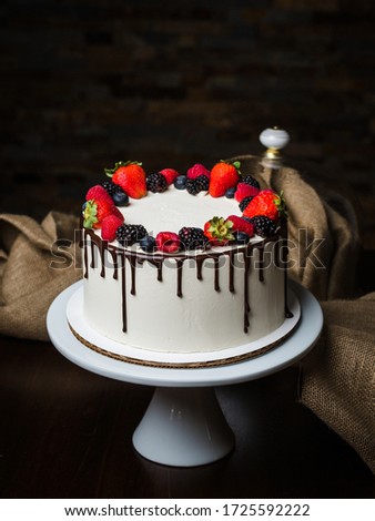 Beautiful white cake decorated with berries. Handmade work