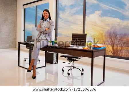 Portrait of business woman in bright modern office with sunset in the background