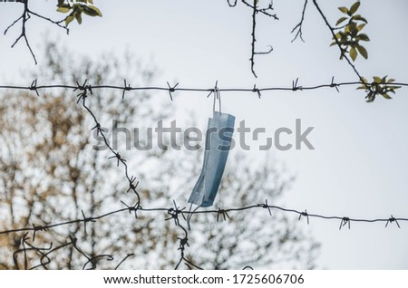 medical mask on a background of barbed wire