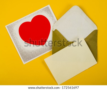 picture with a red heart valentine, lies with the old open envelope on a yellow background in studio 