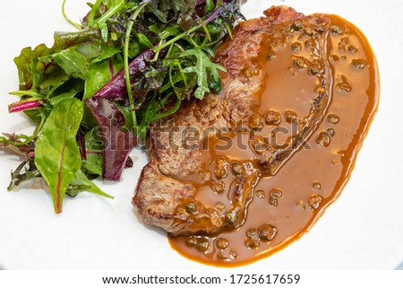 steak with peppercorn sauce and salad 
