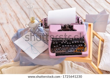 Pink vintage typewriter with a white sheet of paper and a letter