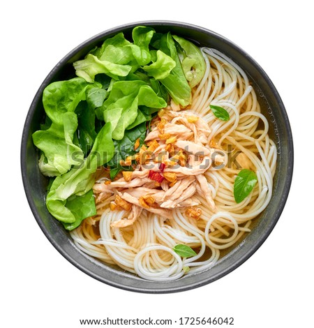Guay Tiew Gai Cheek or Thai Chicken Noodle Soup in black bowl isolated on white backdrop. Guay Tiew Gai is Thailand cuisine soup with rice noodles, chicken meat, sauces, greens. Thai food. Top view