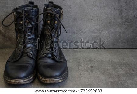 Pair of black leather retro shoes on grey background with copy space. 
Close up photo. 
