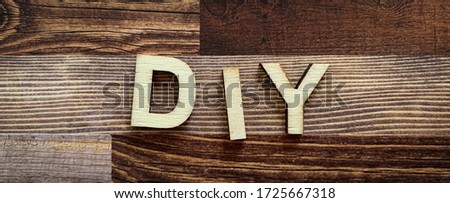 Photo of wood letters spelling out DIY on a rustic plank wood background. Horizontal banner design. Home repair, crafts etc