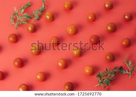 Colorful pattern of cherry tomatoes on red background